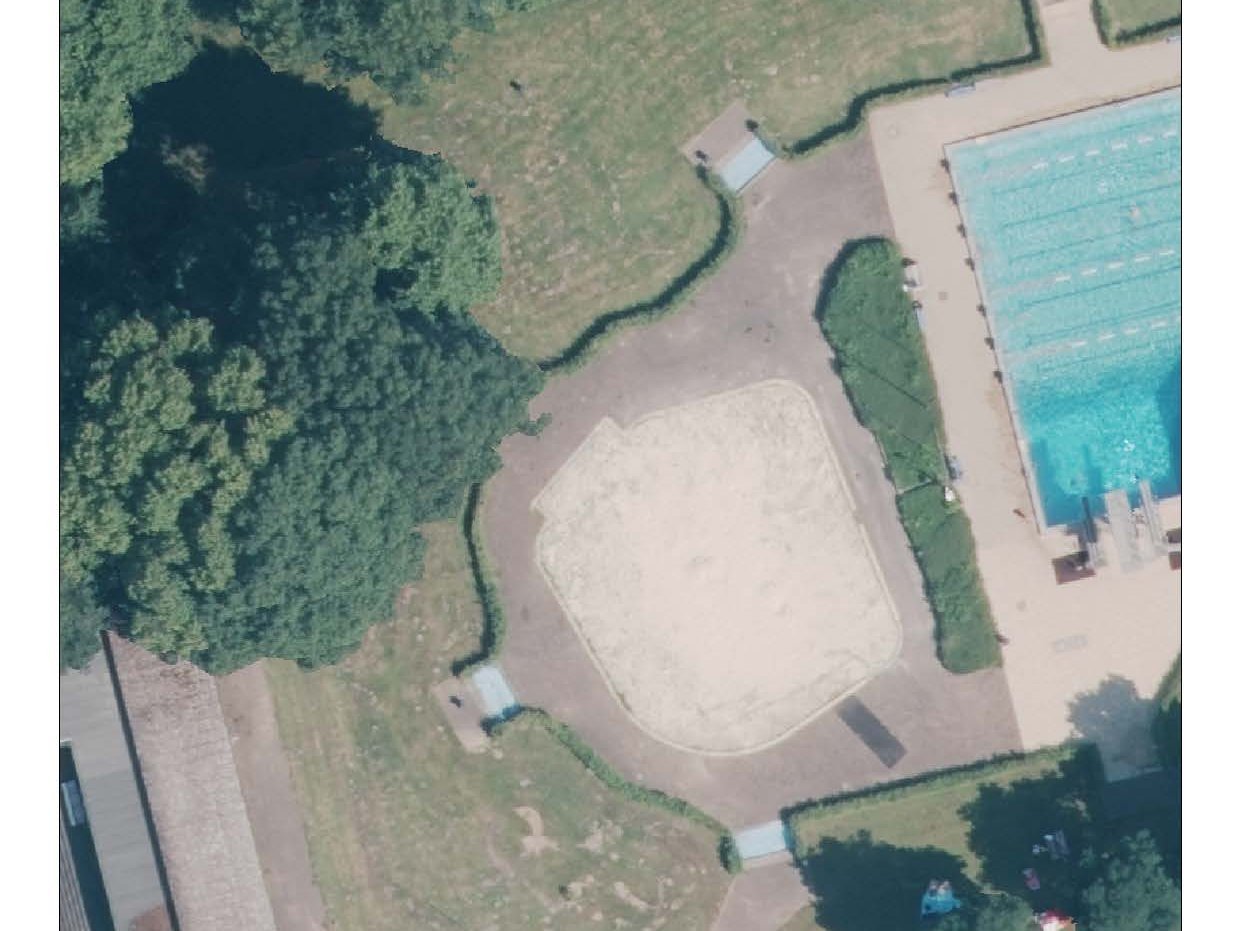 Dsa Bild zeigt die Vogelperspektive auf ein Freibad mit Schwimmbecken, Liegewiesen, Wegen und Bäumen