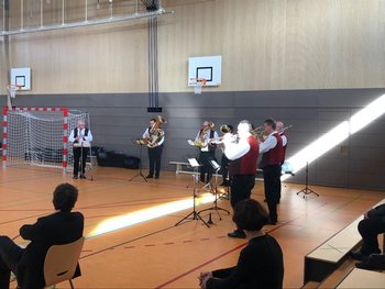 Stadt Weiden Das Bild zeigt mehrere Blasmusiker in einem Halbkreis in einer Turnhalle aufgestellt.