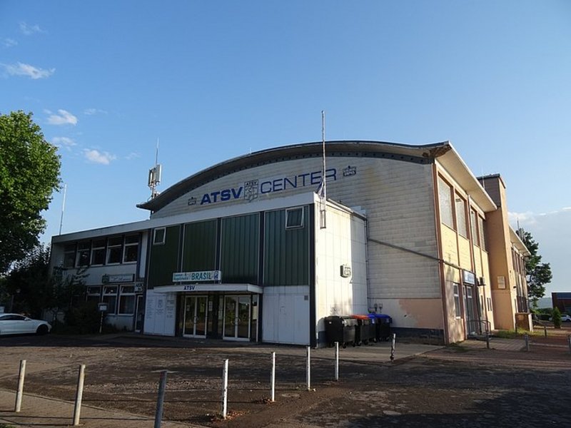 Das Bild zeigt ein baufälliges Gebäude mit der blauen Aufschrift ATSV Center.