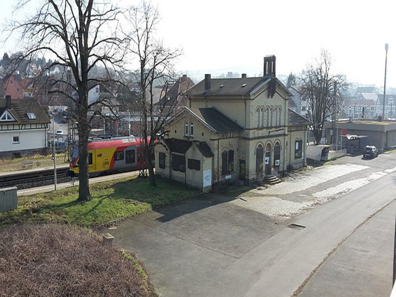 Das Bild zeigt ein freistehendes baufälliges Bahnhofsgebäude.