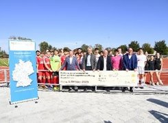 Foto Niedermeyr, hausdesbildes, Mering Das Bild zeigt eine Gruppe von Menschen, die hinter einem großen Banner posieren.