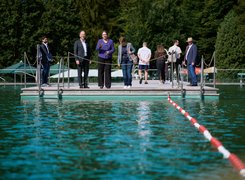 Quelle: BMWSB / Henning Schacht Eine Gruppe Menschen steht am Rand eines Schwimmerbeckens in einem Freibad.