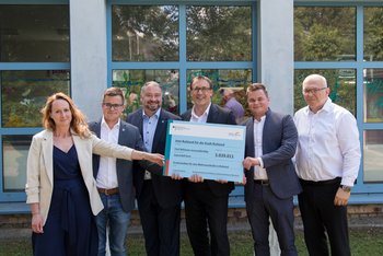 Quelle: Eventfotoservice Frenzel/ Ruhleben Man sieht sechs Personen, die einen symbolischen Spendenscheck an die Stadt Ruhland lachend in die Kamera halten.