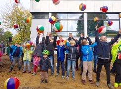 Das Bild zeigt Kinder und Erwachsene beim Spatenstich