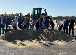 Quelle: Markt Arnstorf Das Bild zeigt eine Gruppe von Menschen, die bei strahlendem Sonnenschein einen Spatenstich vollziehen.