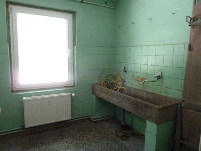 Das Bild zeigt einen in die Jahre gekommenen Waschraum mit Waschbecken.