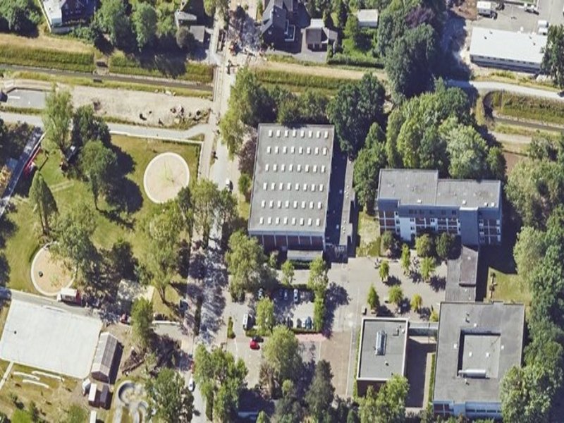 Das Bild zeigt eine Luftaufnahme mehrerer Gebäude und Außenbereiche.