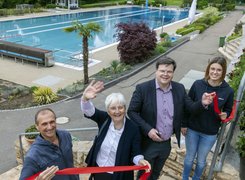 Frieder Scheiffele, Stadtverwaltung Ebersbach Das Bild zeigt vier Personen, die auf einer Treppe vor einem Schwimmbecken stehen. Sie halten ein durchgeschnittenes rotes Band in den Händen.