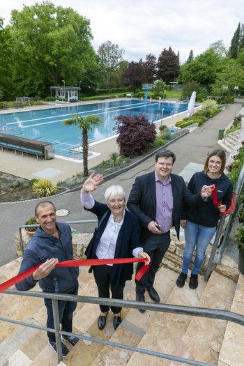 Frieder Scheiffele, Stadtverwaltung Ebersbach Das Bild zeigt vier Personen, die auf einer Treppe vor einem Schwimmbecken stehen. Sie halten ein durchgeschnittenes rotes Band in den Händen.