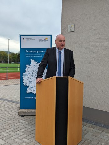 Sonderhausens Bürgermeister Steffen Grimm steht an dem Redepult würdigt die Sportanlange „Am Göldner“ bei der Wiedereröffnung als Ort, an dem gemeinsam Erinnerung gesammelt werden können.