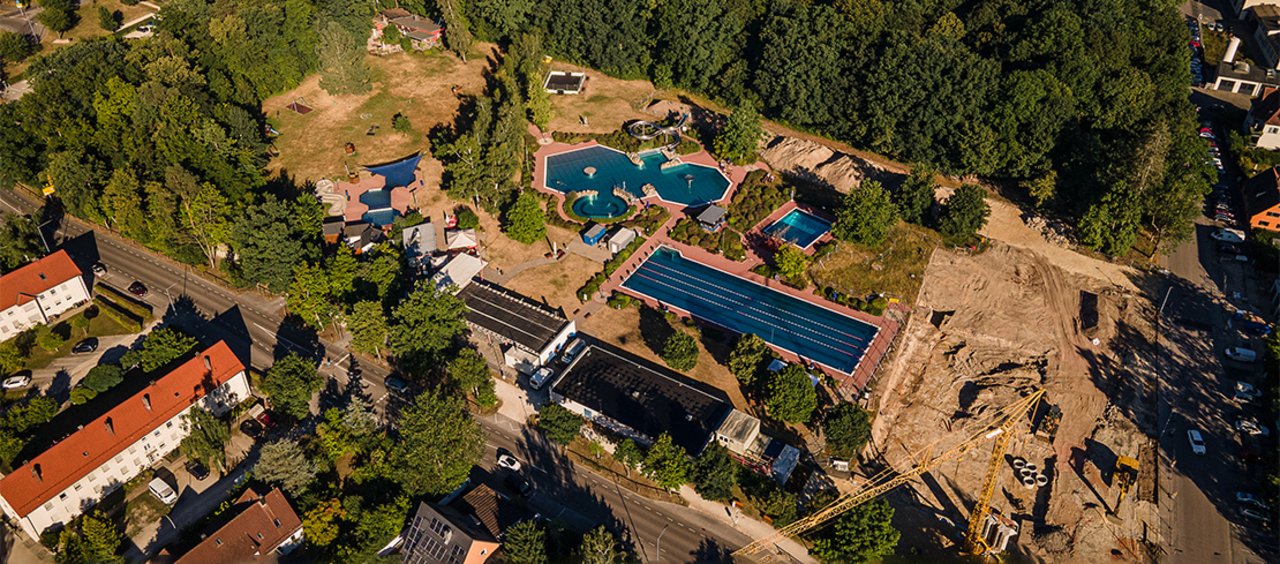 Luftaufnahme der Baustelle des Ersatzneubaus eines Hallenbades in Schwabach, Bayern, neben dem bereits bestehenden Freibad 