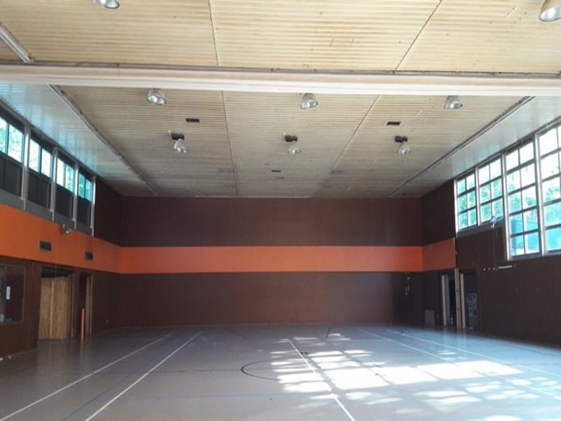 Das Bild zeigt eine Sporthalle mit dunkelbraunen Wänden.