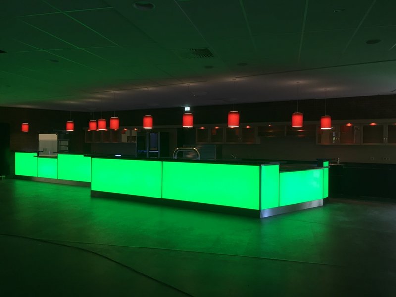 Das Bild zeigt einen freistehenden Thekenbereich mit grün hinterleuchtetem Tresen.