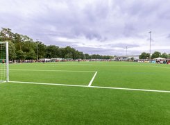 Quelle: Foto: Mike Paul Das Bild zeigt einen Fußballplatz, wo ein Spiel ausgetragen wird. Zuschauer stehen um das Spielfeld herum.