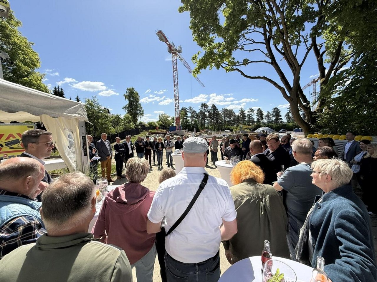Auf dem Bild ist ein großer Platz mit vielen Menschen zu sehen, im Hintergrund ist ein Baukran.