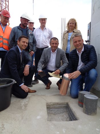 Das Bild zeigt Verantwortliche beim Versenken einer Zeitkapsel. 
