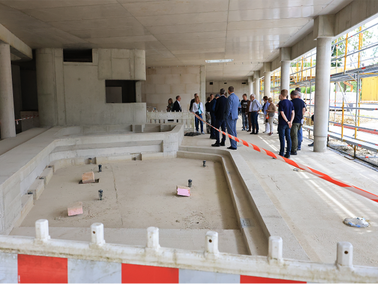 Quelle: Hansestadt Warburg, Pressestelle Das Bild zeigt Menschen auf einer Baustelle. Man sieht das Innere eines Hallenbades, welches saniert wird.