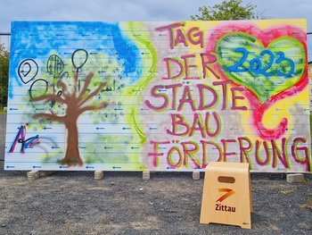 Man sieht ein Graffit zum Tag der Städetbauförderung mit einem Bau und einem Herz.