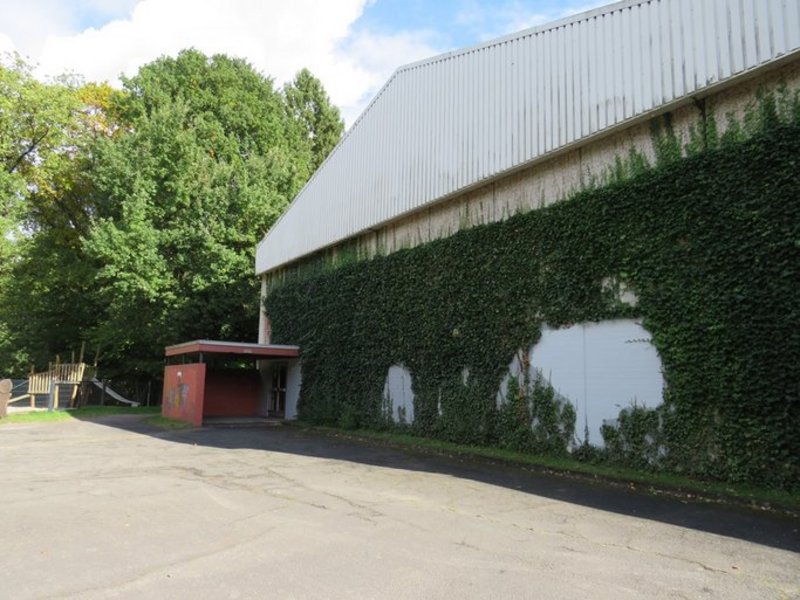 Das Bild zeigt ein Gebäude mit Pflanzen an den Fassaden.