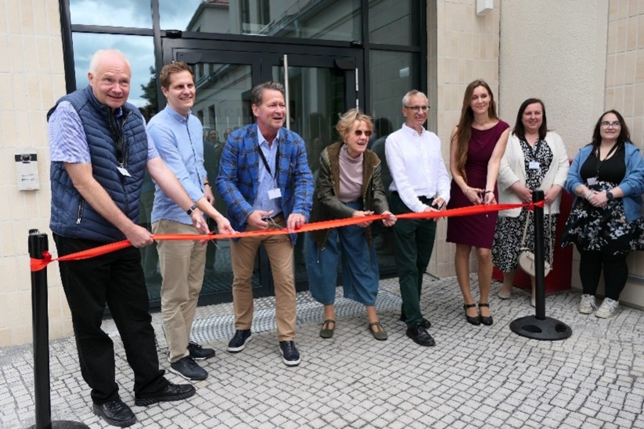 Quelle: Stadt Hohen Neuendorf Das Bild zeigt einen symbolischen Banddurchschnitt. Auf dem Bild zu sehen sind acht Personen. Die Personen halten eine Schere an einem roten Band.
