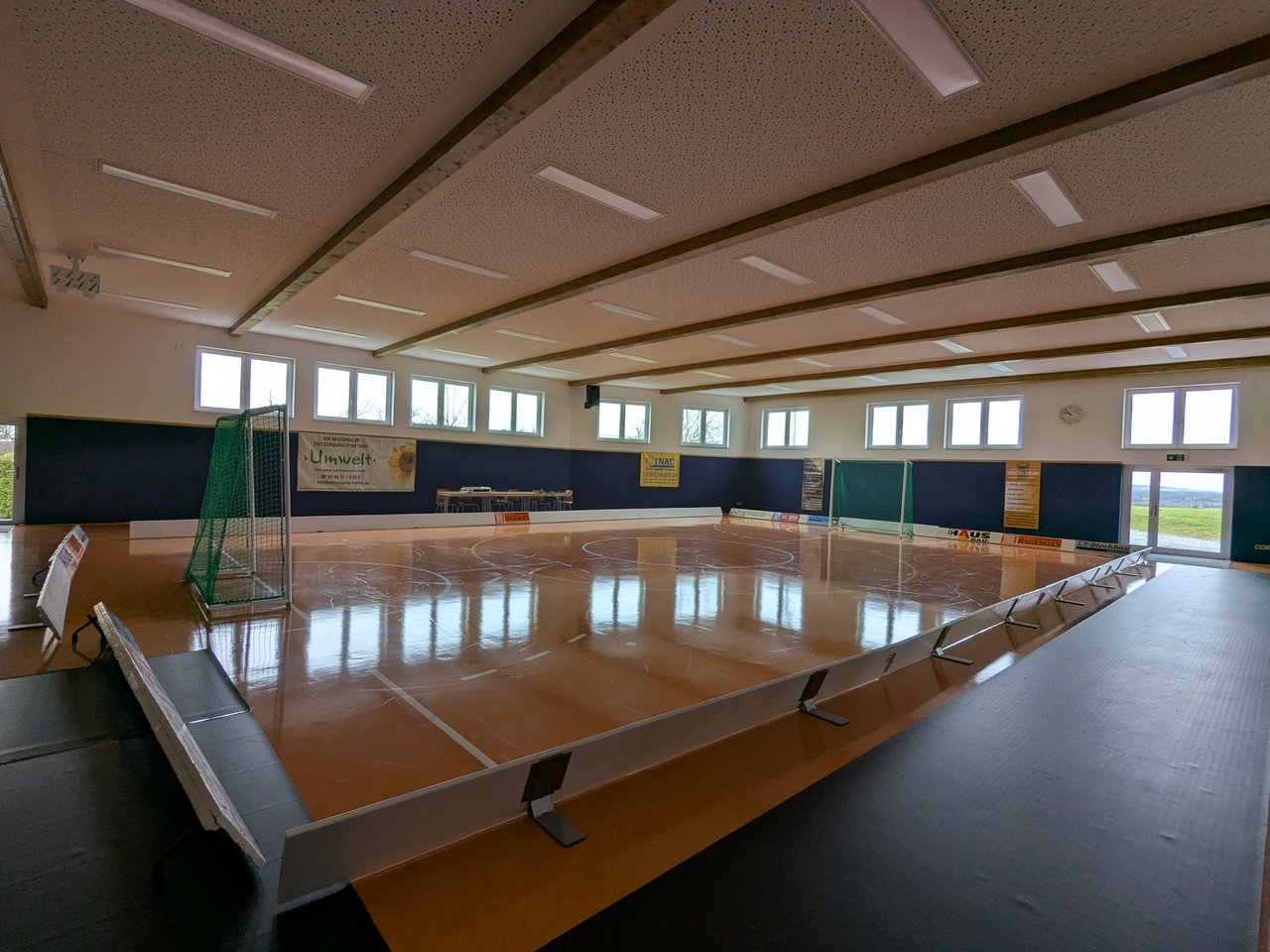 Quelle: A. Knieper, Sportzentrum „Schleizer Hof“ Langenwolschendorf, Innenansicht der Halle Das Bild zeigt eine leere Turnhalle mit orangem Spielfeld mit zwei Toren.