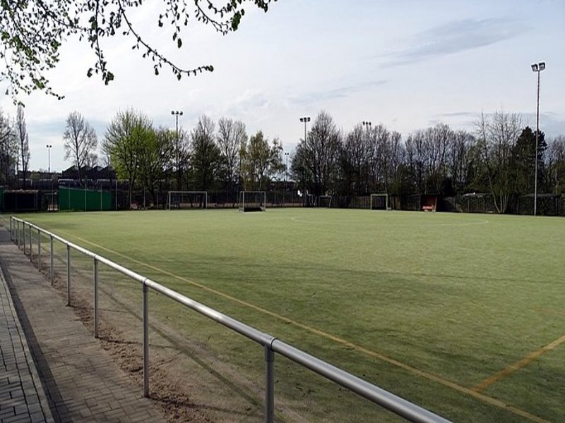 Das Bild zeigt einen Fußballplatz mit einer abgenutzten Rasenfläche.