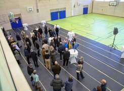 Quelle: Stadt Dachau Das Bild zeigt Menschen bei einem Stehempfang in einer frisch sanierten Sporthalle.