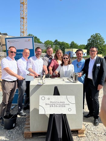 Quelle: Margot Trinter Acht Personen, die für ein Bild posieren. Sie versenken eine Zeitkapsel.