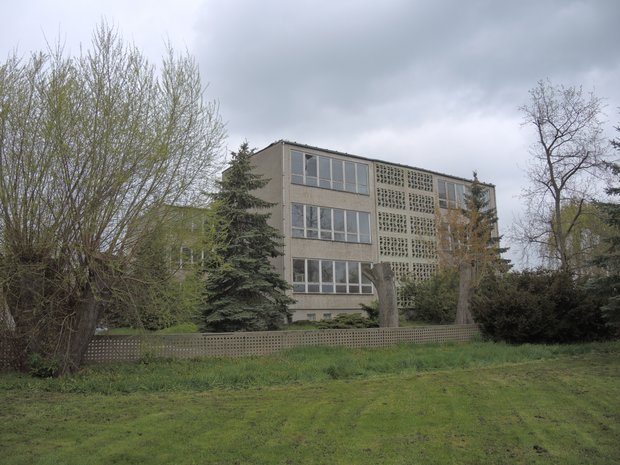 Außenansicht eines in die Jahre gekommenen grauen Gebäudes.