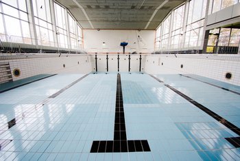 Man sieht ein leeres Hallenbadbacken, aus dem das Wasser ausgelassen wurde.