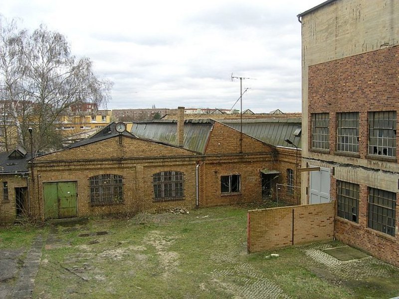 Das Bild zeigt ein industrielles Gebäudeensemble aus Backsteinen.