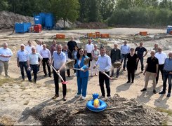 Juliane Fischer, Haren (Ems) Auf dem Bild ist eine Reihe von Menschen auf einer Baustelle zu sehen. Die vordersten drei Personen haben Spaten in der Hand. Alle lächeln in die Kamera.