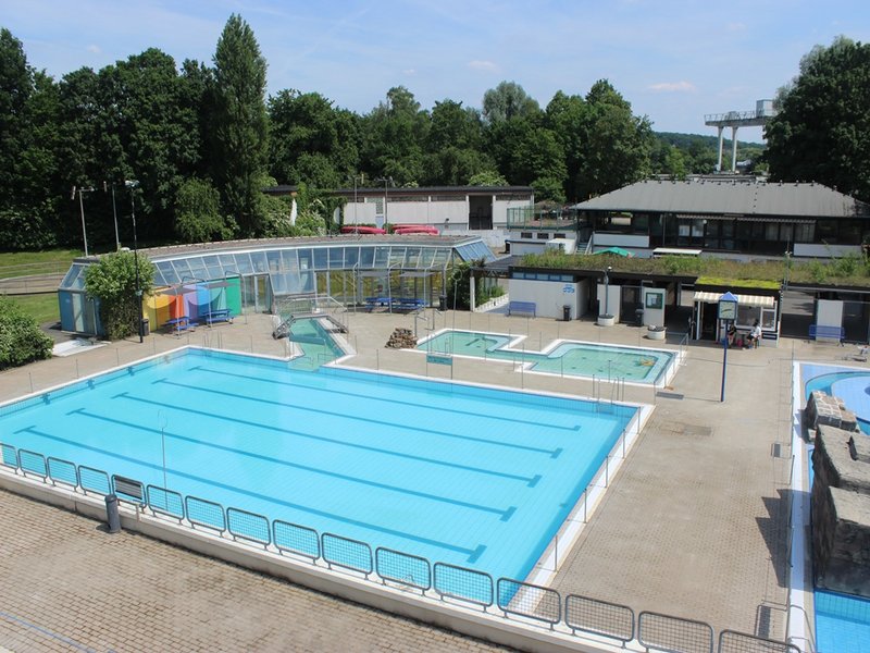 Das Bild zeigt ein Freibad aus der Luft mit einem 25m Schwimmerbecken, und Kinderschwimmbecken.