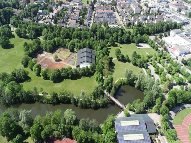 Das Bild zeigt eine Luftaufnahme von einem Gebiet mit Häusern und Grünflächen.