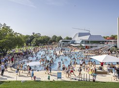 Das Bild zeigt ein Freibad, wo viele Menschen baden.