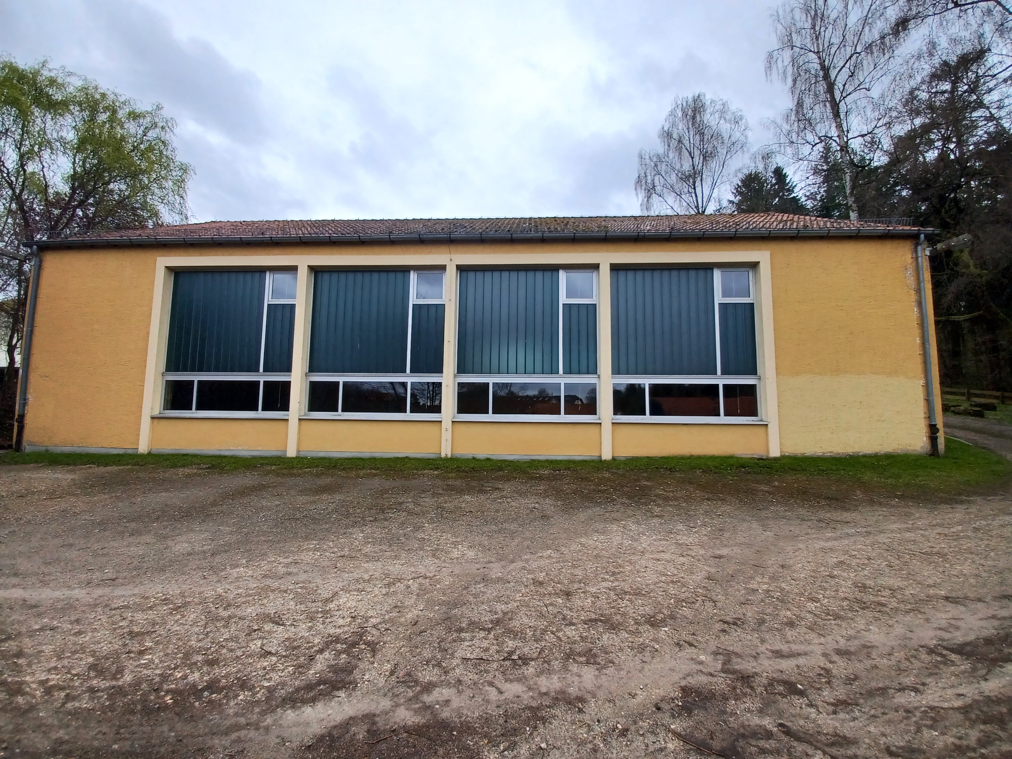 Quelle: Stadt Alfeld (Leine) Hochbauamt Man sieht eine alte Sporthalle von außen.