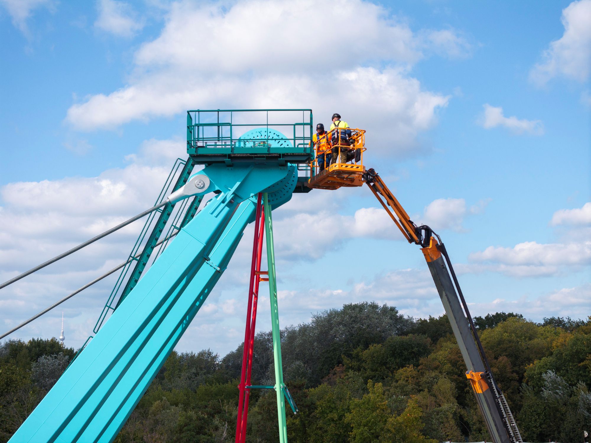 Frank Sperling Das Bild zeigt einen Kran, der an einem Bauteil eines Riesenrades arbeitet.