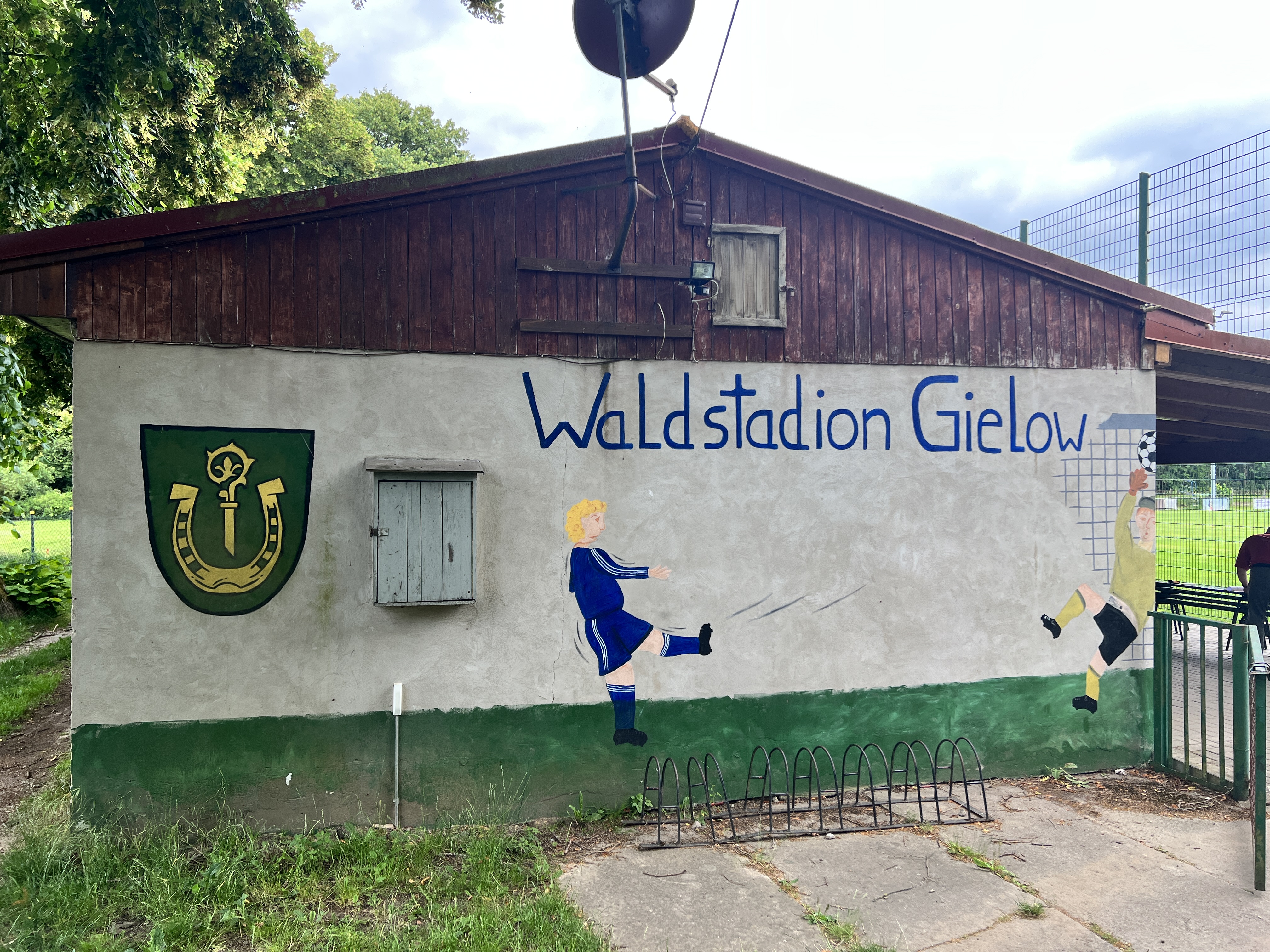 Quelle: Stadt Malchin Man sieht die Außenwand eines Gebäudes auf dem ein Fußballspieler aufgemalt ist sowie der Schriftzug "Waldtadion Gielow".