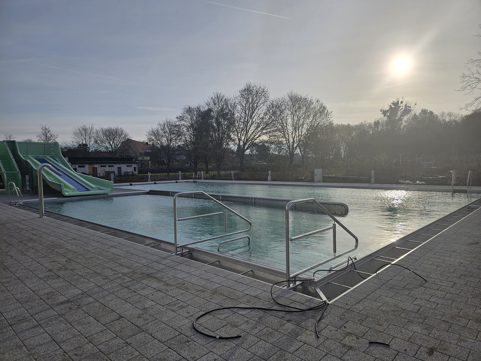 Bilder, Sport und Freizeit Salzgitter GmbH Das Bild zeigt ein Freibad mit Becken und Rutsche.