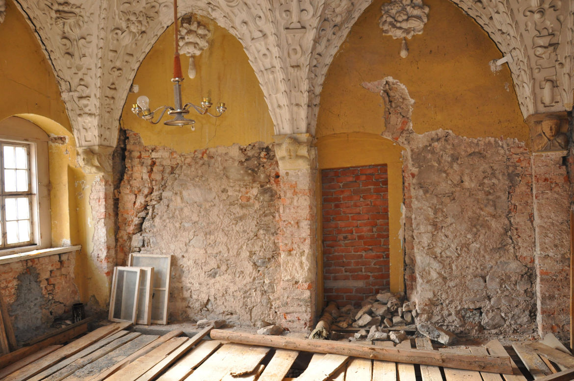 Das Bild zeigt einen Innenraum mit zum Teil eingerissenen Wänden und Bodenplatten.