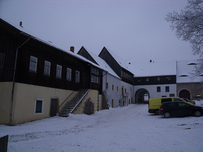 Das Bild zeigt mehrere baufällige Gebäude in einer Schneelandschaft.