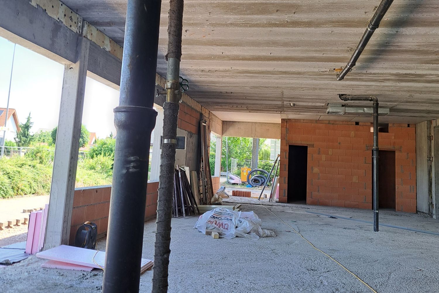 o	i. A. für den Eigenbetrieb Schule und Gebäudewirtschaft, Landkreis Bergstraße Zu sehen ist die Innenansicht des sanierten Gebäudes im Rohbau mit  Rohren, Betondecke und Ziegelwänden.