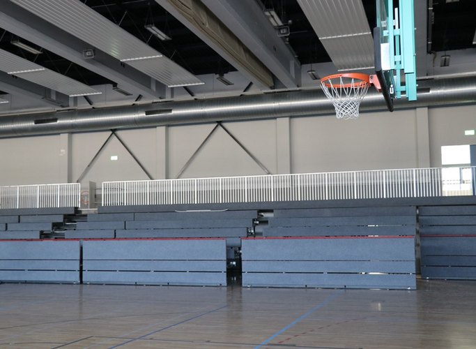 Das Bild zeigt eine ausfahrbare Tribüne in einer Sporthalle.