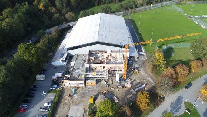 Das Bild zeigt die Luftaufnahme einer Baustelle an einer großen Halle.
