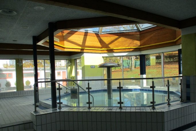 Das Bild zeigt ein Schwimmbecken in einem Hallenbad.