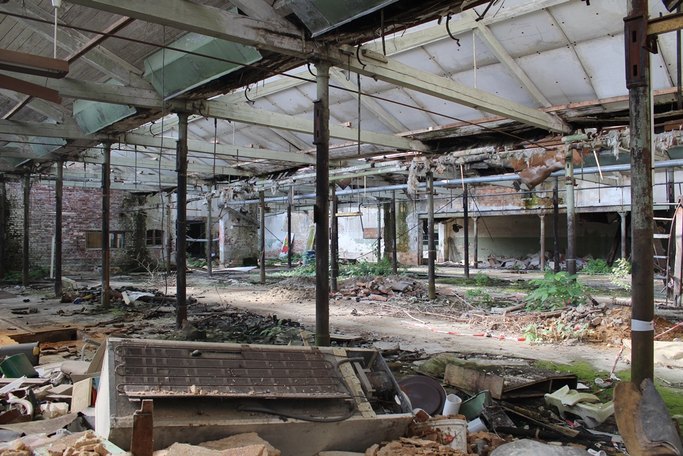 Das Bild zeigt eine verwahrloste Industriehalle von innen.
