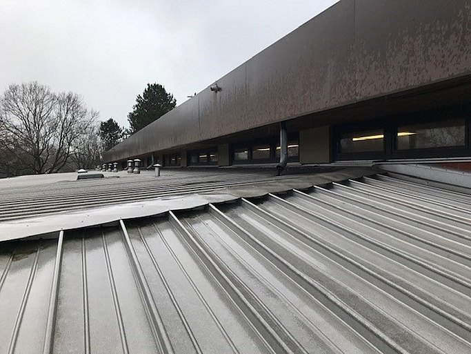 Das Bild zeigt das Flachdach der Sporthalle von oben.