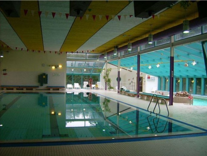 Das Bild zeigt ein Schwimmbecken in einem Hallenbad.