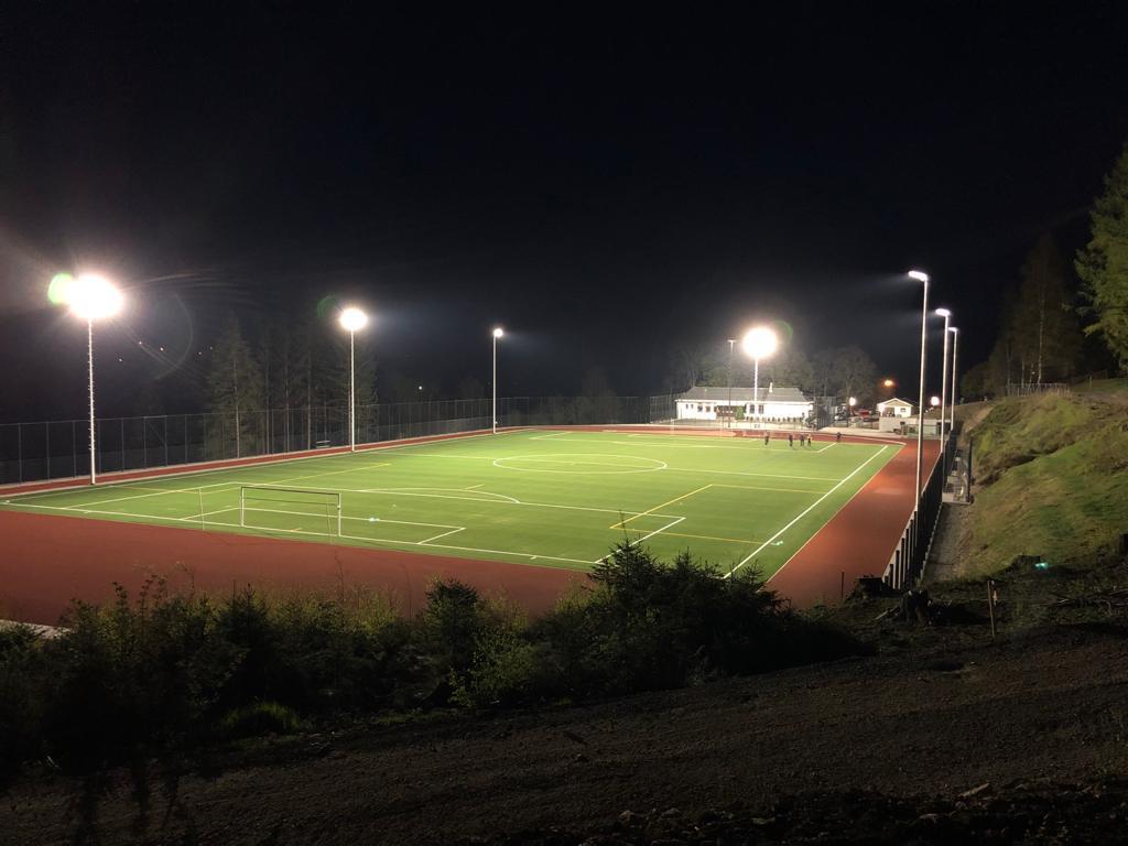 Das Bild zeigt eine beleuchtete Sportanlage bei Nacht.