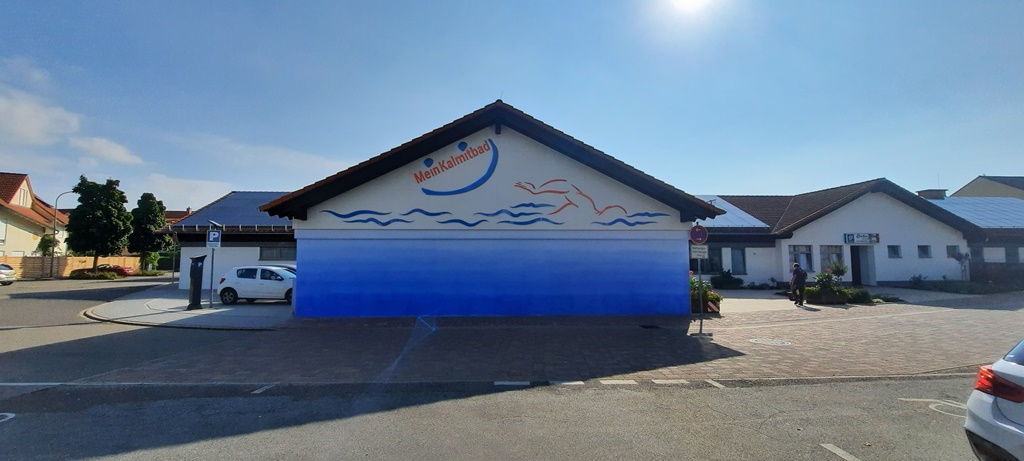 Das Bild zeigt eine Wand die mit einem abstrakten Ozean und Wellen bemalt ist.